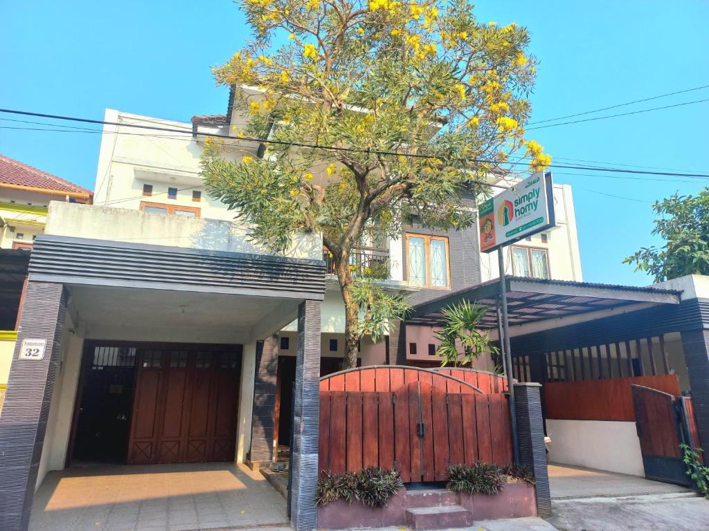 a house with a gate and a tree in front of it at Homestay Jogja dekat Malioboro by Simply Homy in Yogyakarta