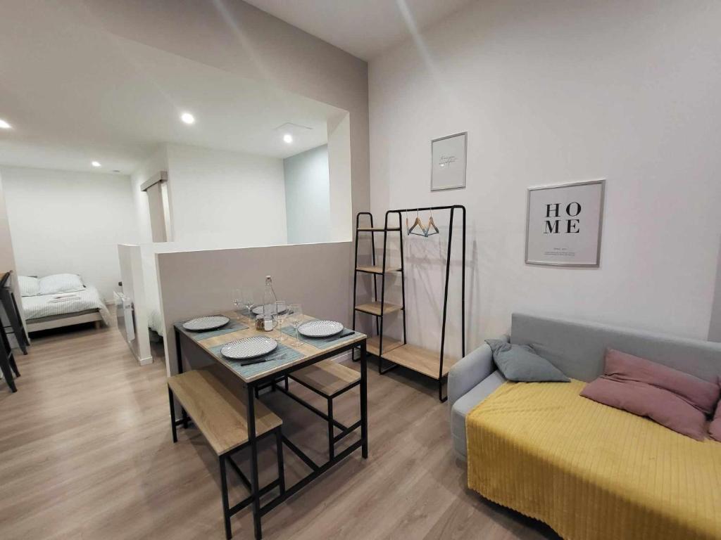 a living room with a couch and a table in a room at Appartement canada 1 in Valenciennes