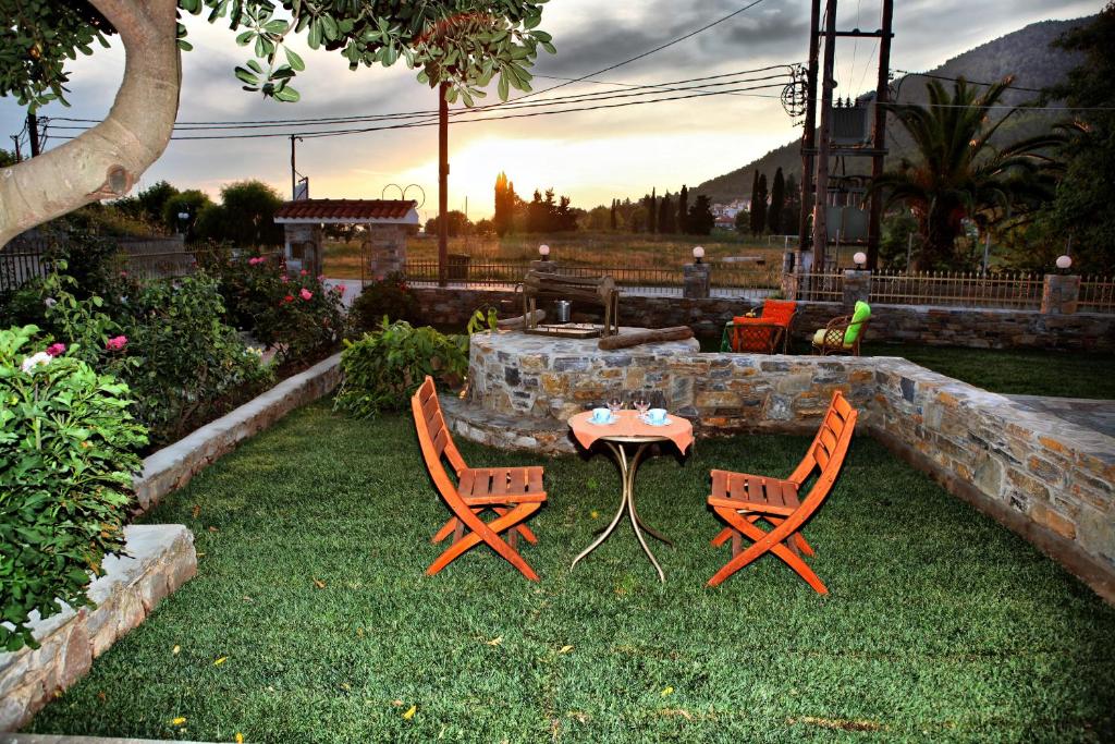 a patio with two chairs and a table in the grass at Maria Studios in Neo Klima