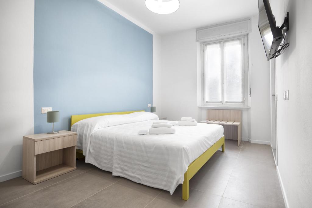 Habitación blanca con cama y ventana en b&b Amaca, en Pavia