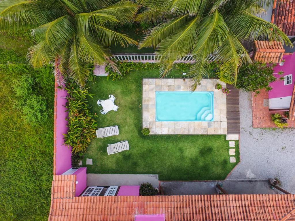 uma vista sobre um quintal com uma piscina em Suítes casa rosada em Cabo Frio