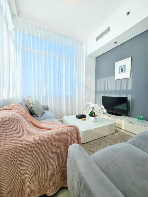 uma sala de estar com uma cama e um sofá em Luxury Botanica Apartment 121 em Dubai