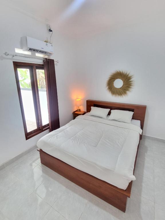 een slaapkamer met een groot bed en een raam bij Tropical home with office in Krambitan