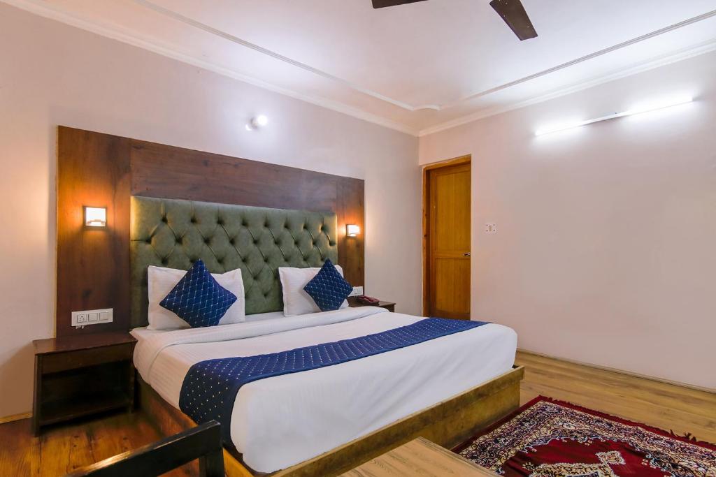 a bedroom with a large bed with blue pillows at FabHotel The Moon in Manāli
