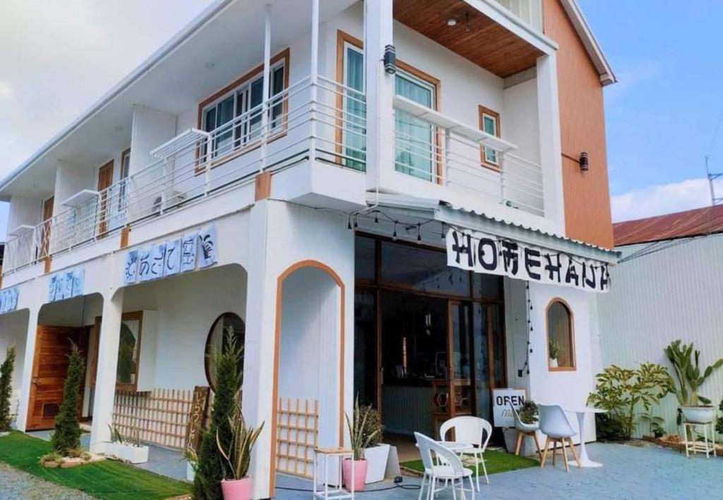 a large white building with tables and chairs in front of it at Homehana Pua in Pua