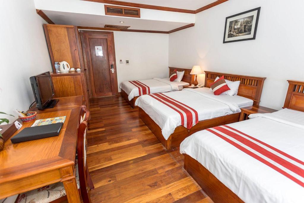 Postel nebo postele na pokoji v ubytování Cheathata CTA Hotel Siem Reap