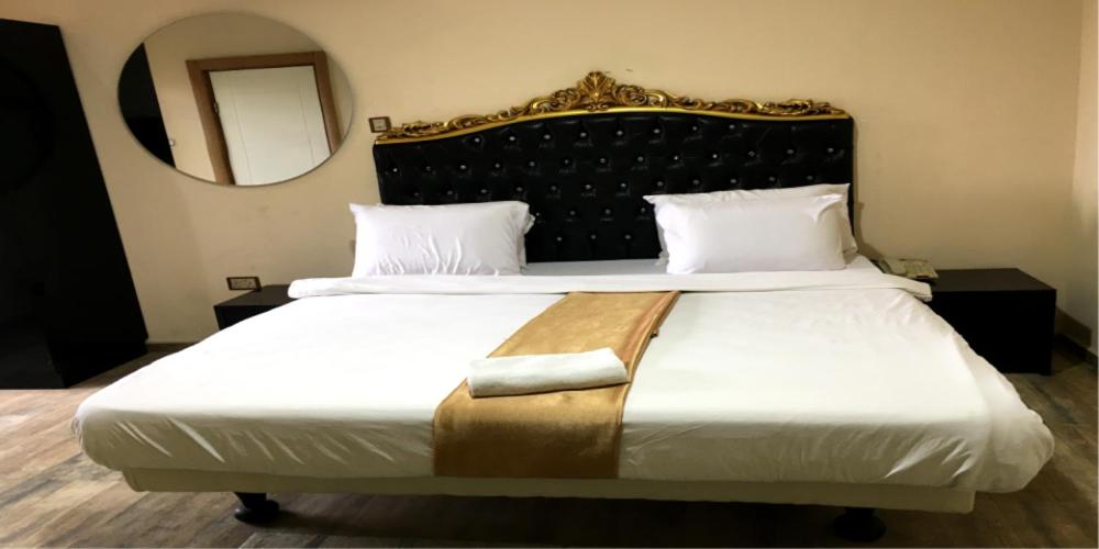 Postel nebo postele na pokoji v ubytování Ellyxville Hotel