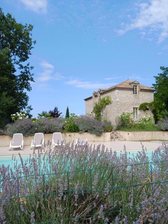 a group of white chairs and a house at LA MAISON FORTE in Montaut