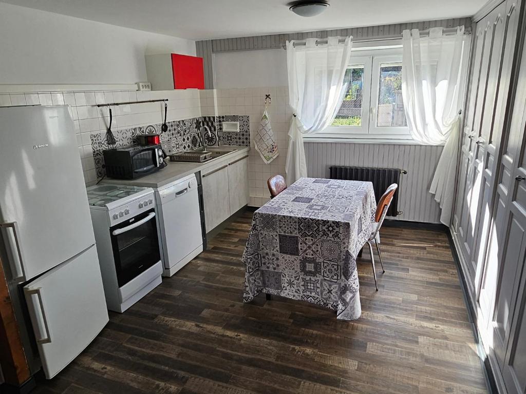 LA BOURZEDE في Langeac: مطبخ صغير مع طاولة عليها قطعة قماش