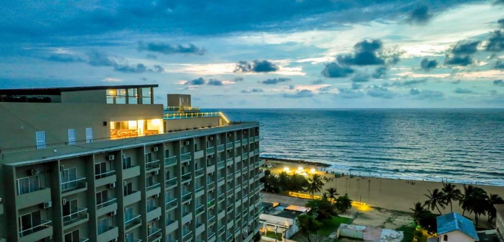 a view of a building and the ocean at night at Corundum Breeze Negombo in Negombo