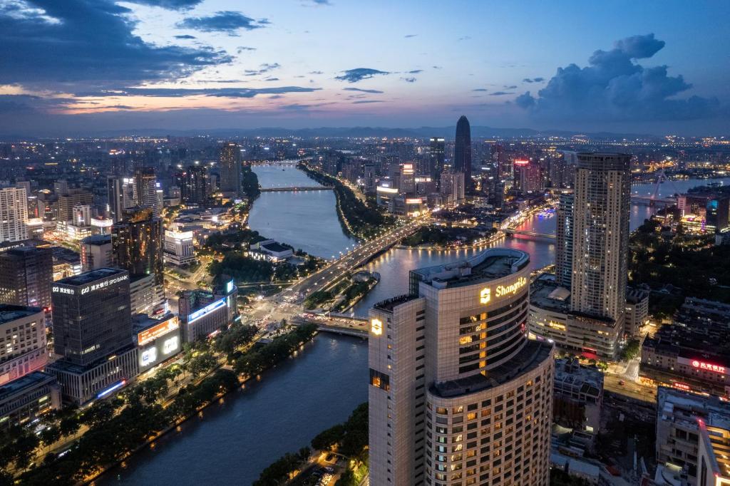 um horizonte da cidade à noite com um rio e edifícios em Shangri-La Ningbo - The Three Rivers Intersection em Ningbo