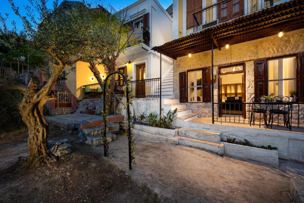 a house with a tree in front of a building at Townhall Apartment in Symi