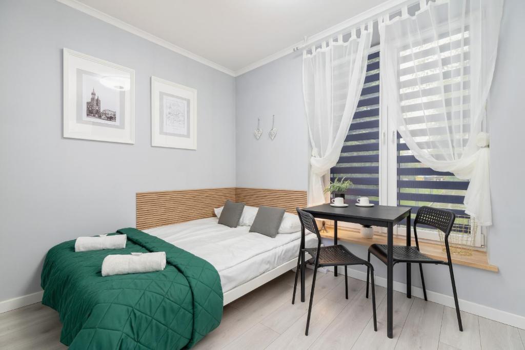 a small bedroom with a bed and a table at Modern Studio Radomska by Renters in Krakow