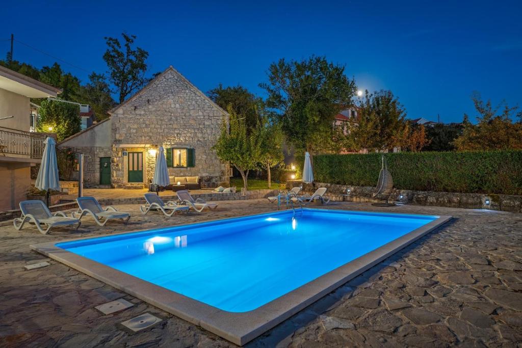 a swimming pool in the yard of a house at Hacienda Sylvia - secluded 4-bedroom villa with 45sqm heated pool in Studenci