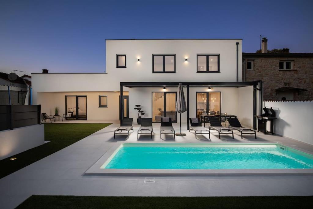 a house with a swimming pool in front of it at Villa Artis by IstriaLux in Loborika