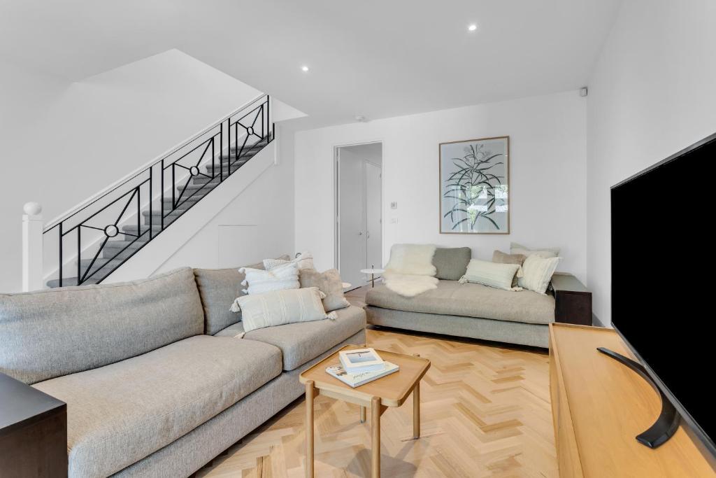 a living room with a couch and a flat screen tv at Bev's Retreat by Ready Set Stay in Melbourne