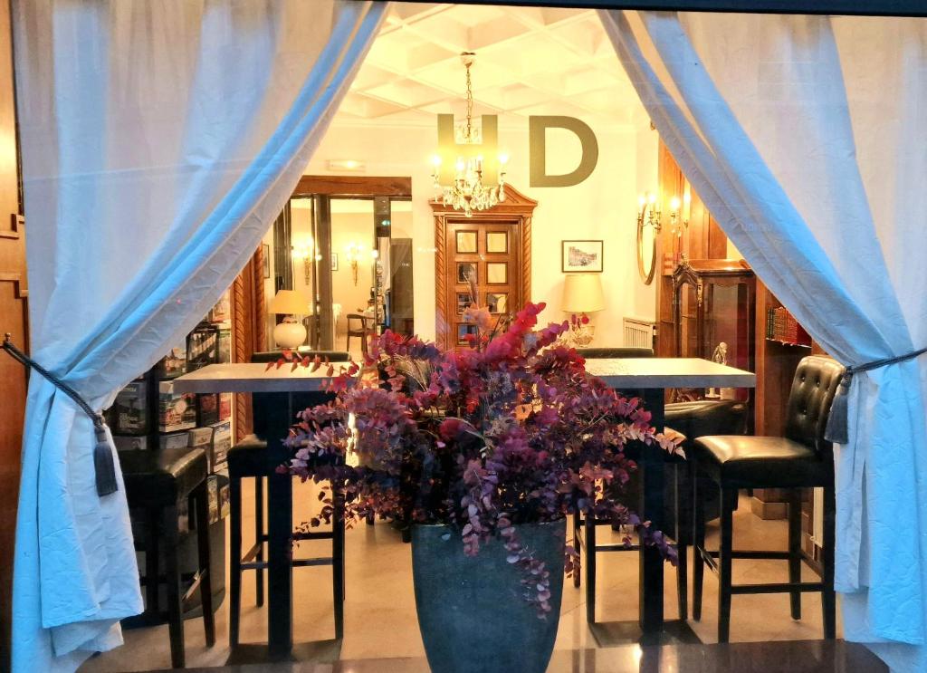 a vase of flowers in a room with a table at Hotel Dandy Rouen centre in Rouen