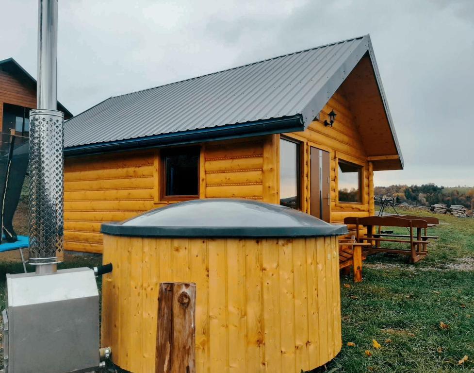 a wooden cabin with a hot tub in front of it at Przystanek Jawory in Wołkowyja