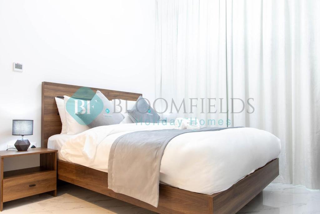 - une chambre avec un lit doté de draps blancs et d'oreillers bleus dans l'établissement Stylish 1 Bedroom In Oasis, à Al Qurayyah