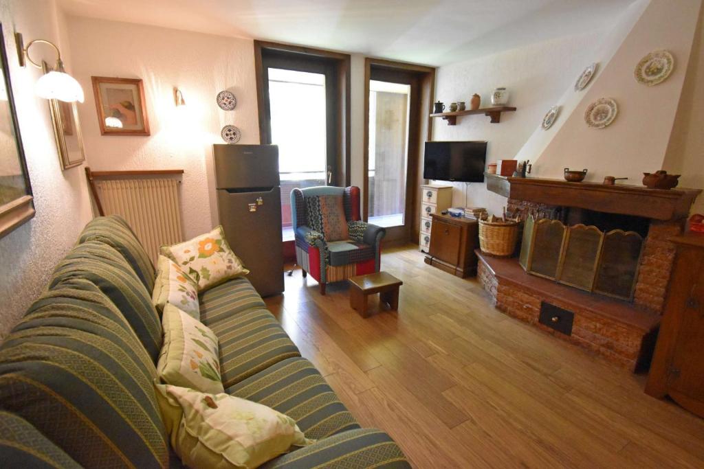 a living room with a couch and a fireplace at Capanna Arnold Apartment in Madonna di Campiglio