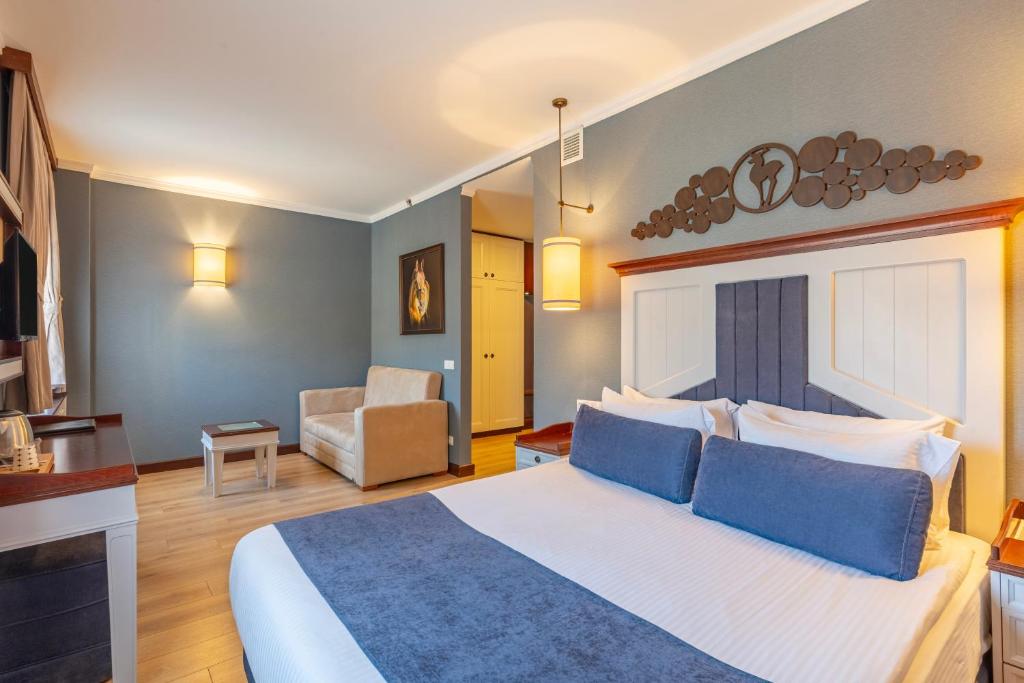 a bedroom with a large bed with blue pillows at Mirada Del Lago in Erciyes