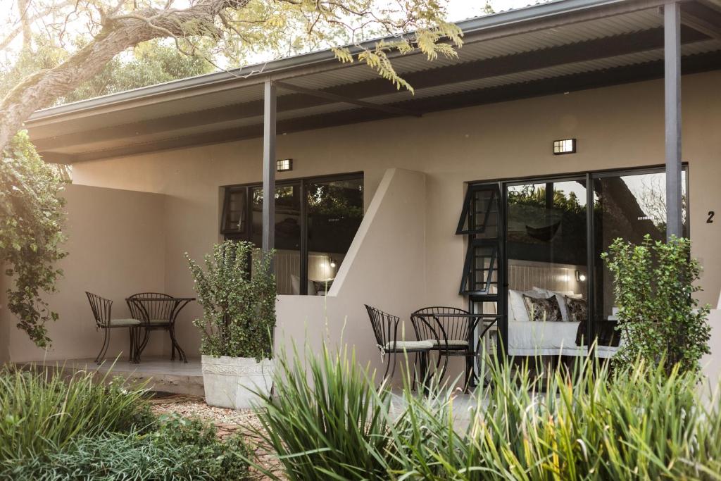 a house with chairs and tables on a patio at Bona Vista Self-Catering Accommodation in Klapmuts