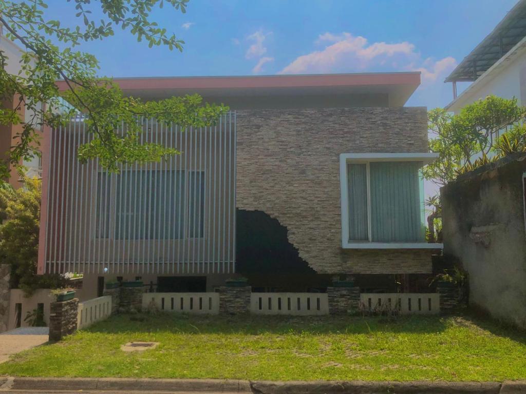una casa con una valla delante en Villa Sentul Onnelik Sentul City Bogor by Villaloka, en Babakan Madang