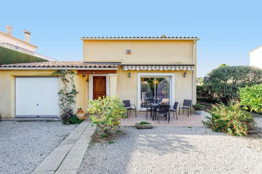 a house with a patio with a table and chairs at Villa la Farigoulo in Juan-les-Pins