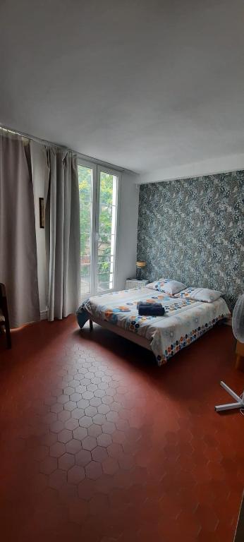 une chambre avec un lit et une grande fenêtre dans l'établissement Studio Rue st Martin, à Paris