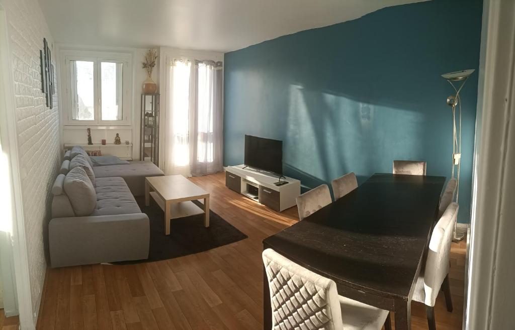 a living room with a couch and a dining room table at Appartement cosy 6 personnes proche gare in Rueil-Malmaison