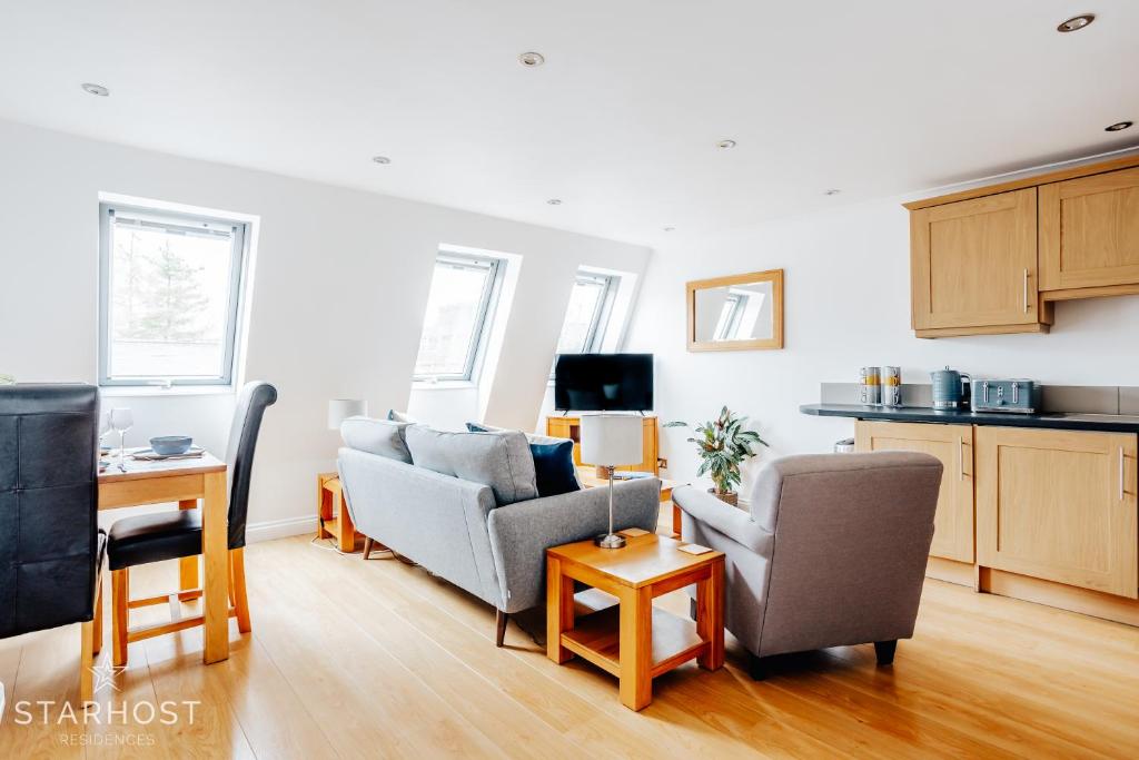 a living room with two couches and a kitchen at Central 3 bed apartment at Regents Court, Newbury in Newbury