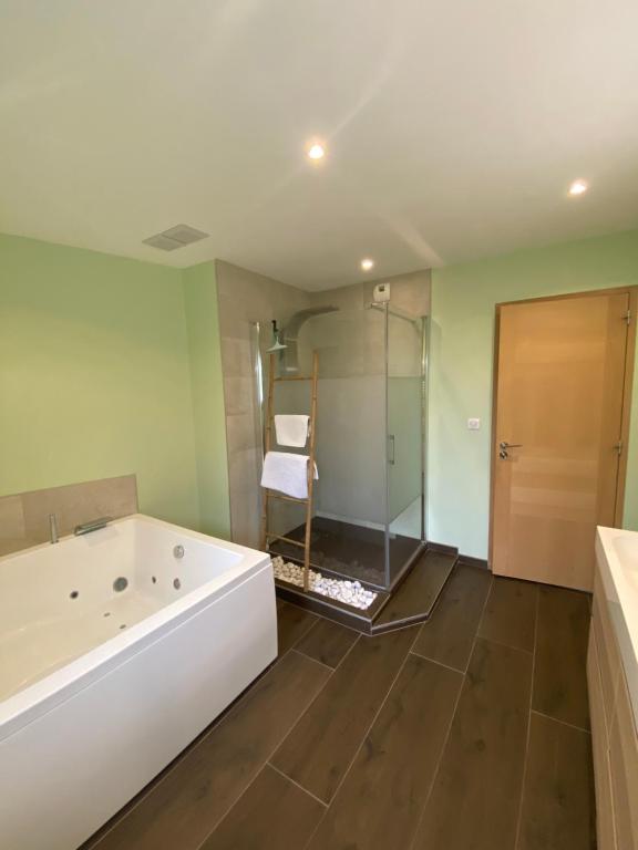a bathroom with a tub and a glass shower at Grange rénovée esprit loft Côte d&#39;Opale in Wierre-Effroy