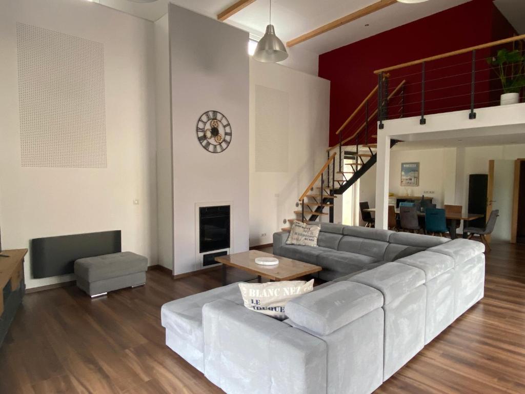 a living room with a couch and a table at Grange rénovée esprit loft Côte d&#39;Opale in Wierre-Effroy