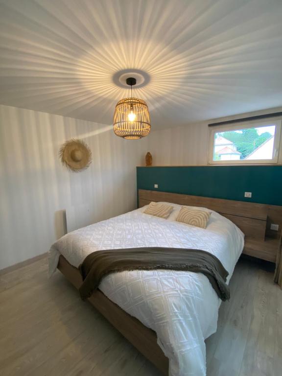 a bedroom with a bed and a chandelier at Grange rénovée esprit loft Côte d&#39;Opale in Wierre-Effroy