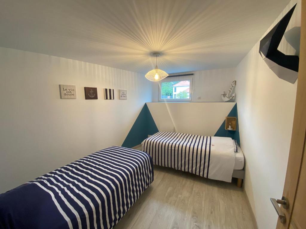 a small room with two beds and a window at Grange rénovée esprit loft Côte d&#39;Opale in Wierre-Effroy