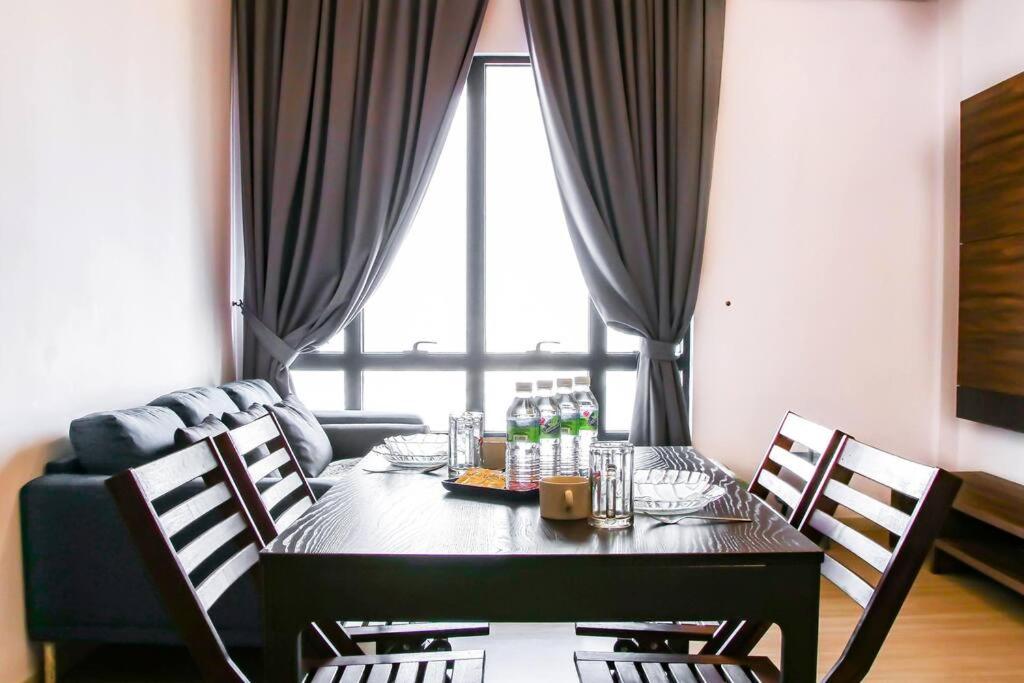 a dining room with a table with chairs and a couch at Near SunwayPyramid 2Bed2Bathroom in Subang Jaya