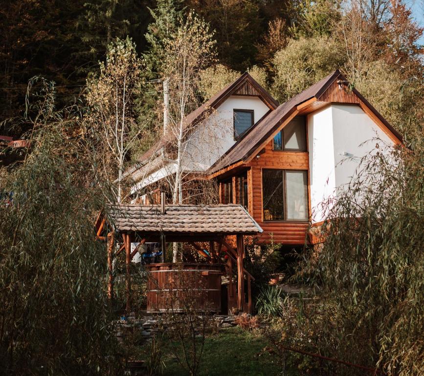 una baita di tronchi nel bosco con alberi di Aproka - Chalet Mignon Adorable small guest house a Sicasău