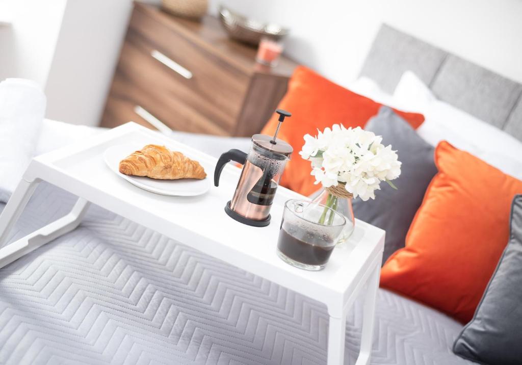 una mesa blanca con un plato de comida y flores en ella en Cosy Apartment by Klass Living Bellshill en Bellshill