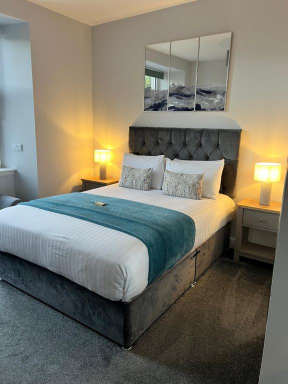 1 dormitorio con 1 cama grande y espejo en la pared en Killorn Guest House, en Oban
