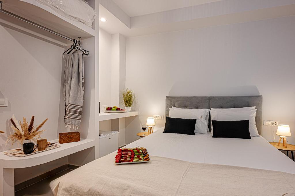 a bedroom with a large bed with a tray of strawberries on it at AMINA APARTMENTS in Zakynthos Town