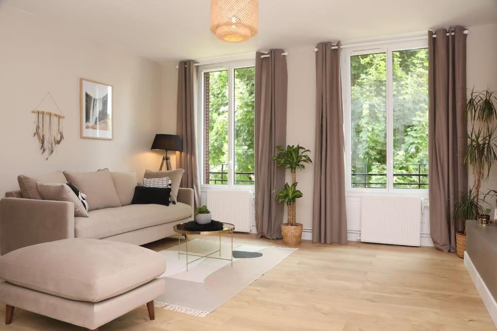 sala de estar con sofá y 2 ventanas en Appartement Le Perchoir by La Boîte En Plus, en Senlis