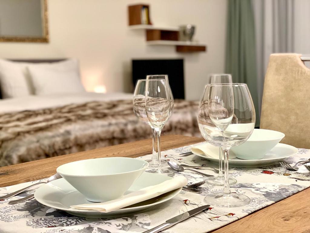 uma mesa com três taças de vinho e pratos em La Suite Swiss Alps em Davos