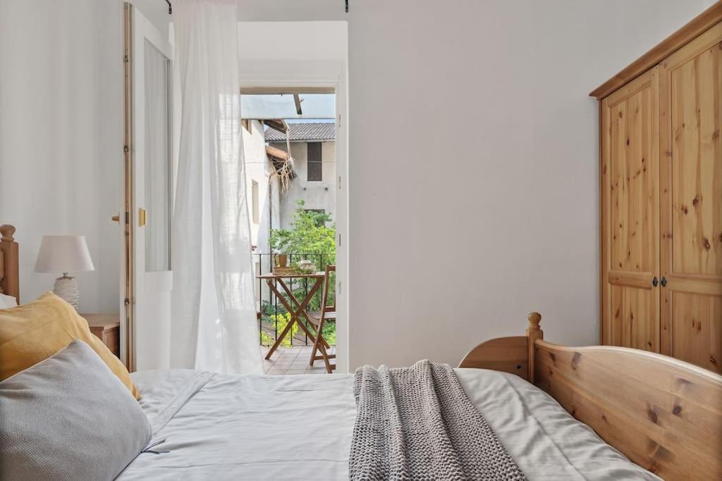 een slaapkamer met een bed en een open deur naar een balkon bij MaCri di TSS' - Per coppie, colazione in balcone, intimo e relax in Levico Terme