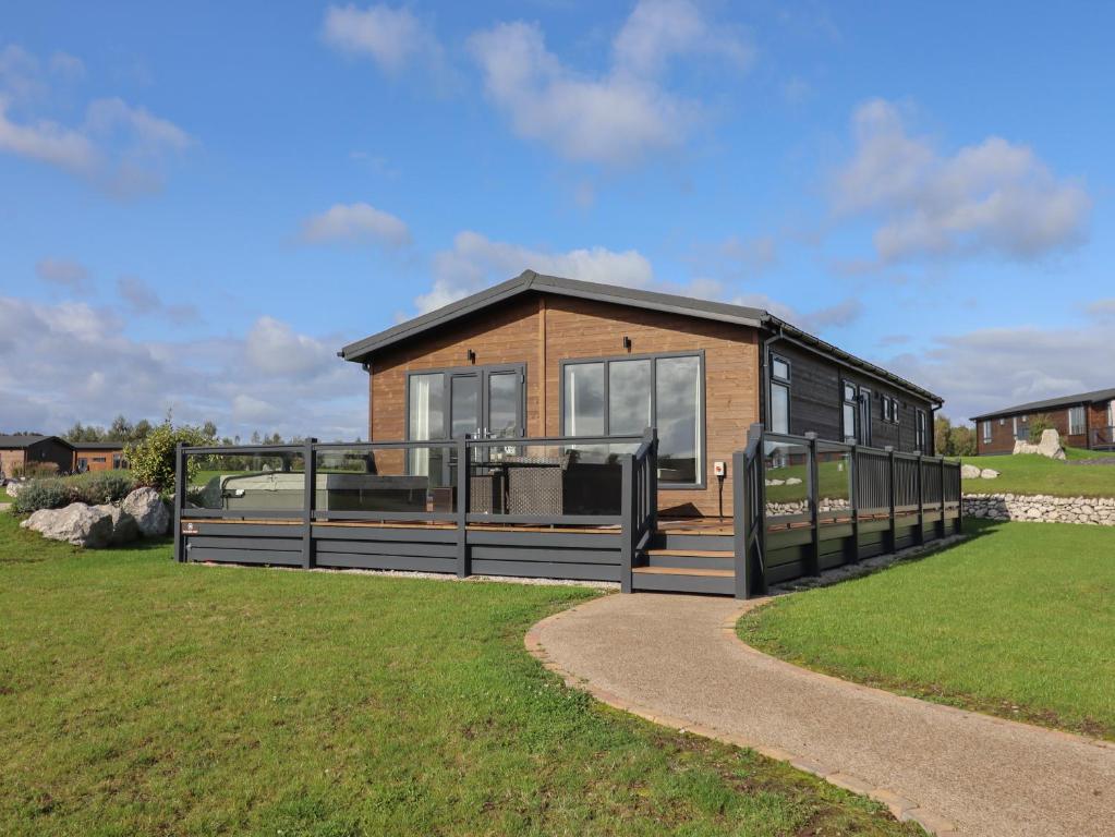 a small house with a porch on a grass field at 35 Delamere Point in Northwich