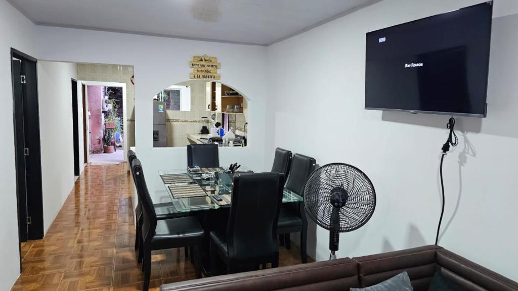 a dining room with a table with chairs and a fan at Casa familiar barranco in Barranquilla