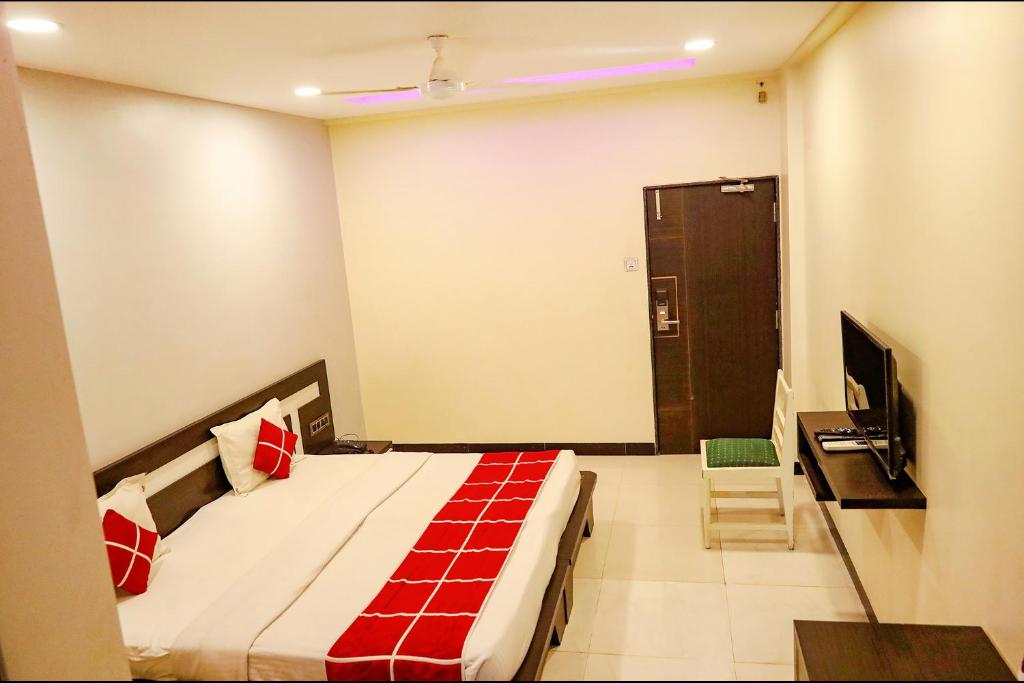 um quarto com uma cama e uma televisão num quarto em FabHotel Sparkling Pearl em Aurangabad