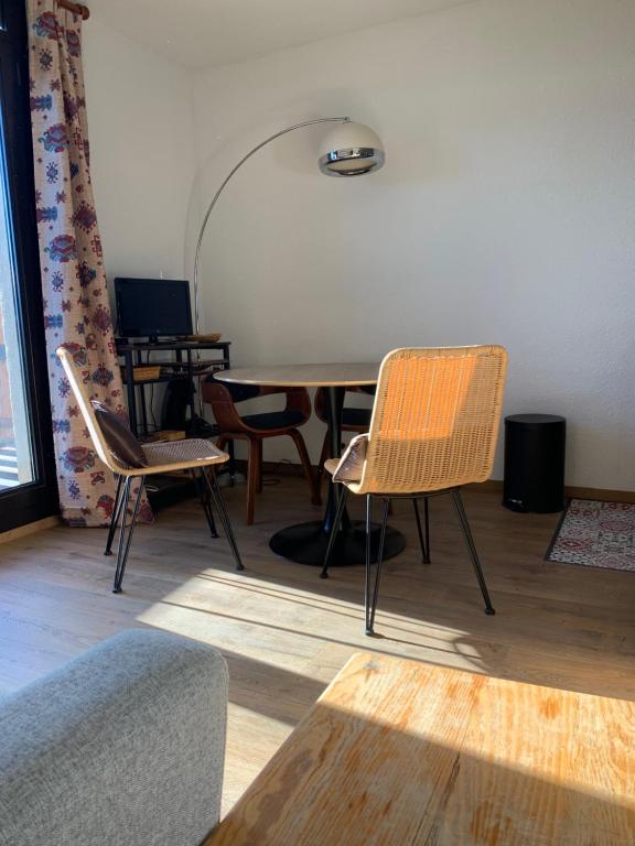 ein Wohnzimmer mit einem Tisch und Stühlen in der Unterkunft Studio avec Balcon Pra chauvet in Uvernet