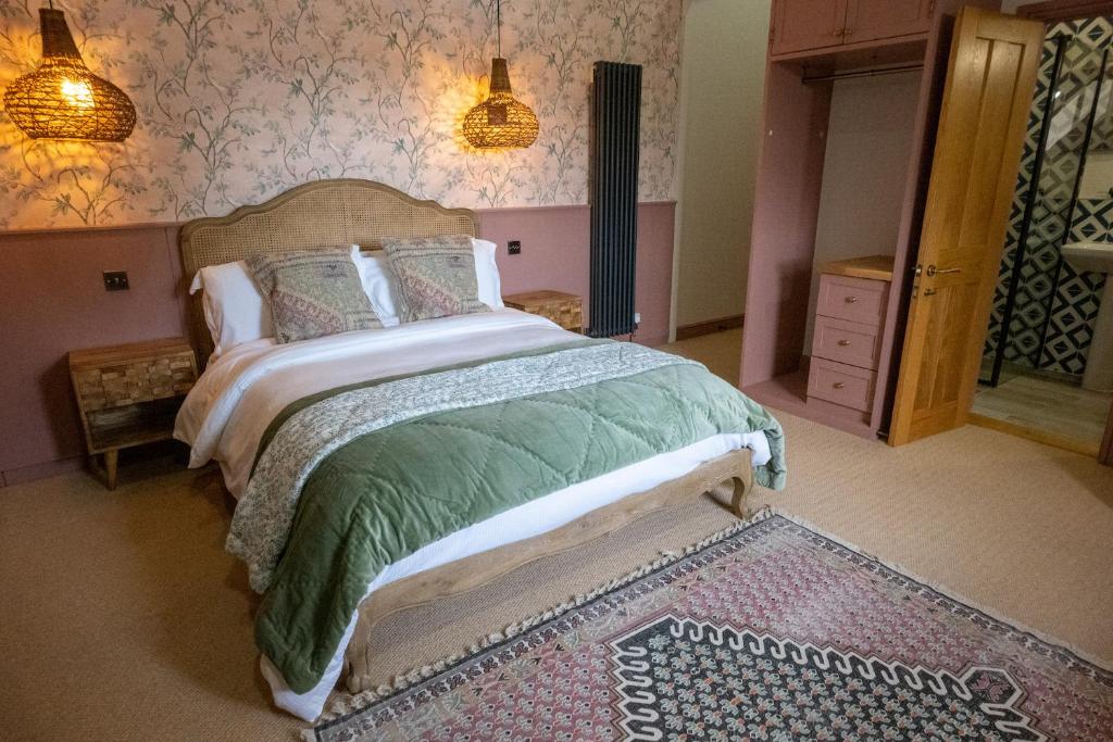 a bedroom with a bed with a green comforter at The Sheep and Penguin in Wells