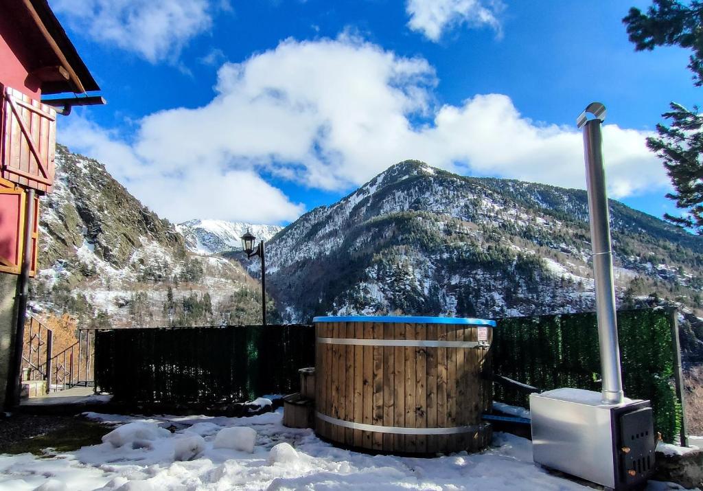 una bañera de hidromasaje en la nieve con montañas en el fondo en Magic Borda Puntal HUT 7983, en Ordino