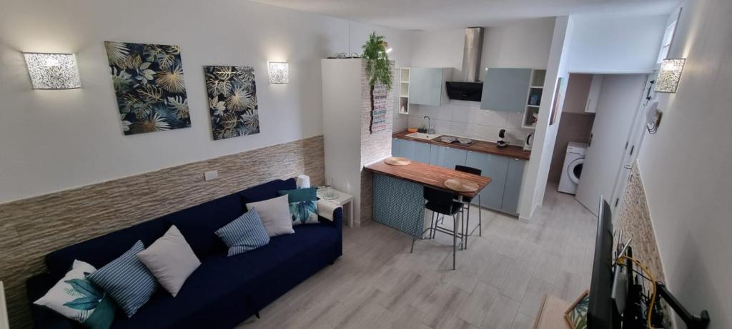 ein Wohnzimmer mit einem blauen Sofa und einer Küche in der Unterkunft Monolocale Splendida casa vacanze in Tenerife del Sur Casa Mimì in Arona